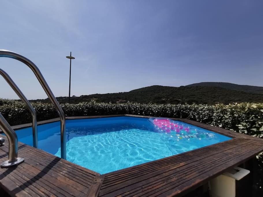 un bain à remous assis à côté d'un banc en bois dans l'établissement Magnifique maison individuel avec piscine hors-sol, à Sainte-Maxime