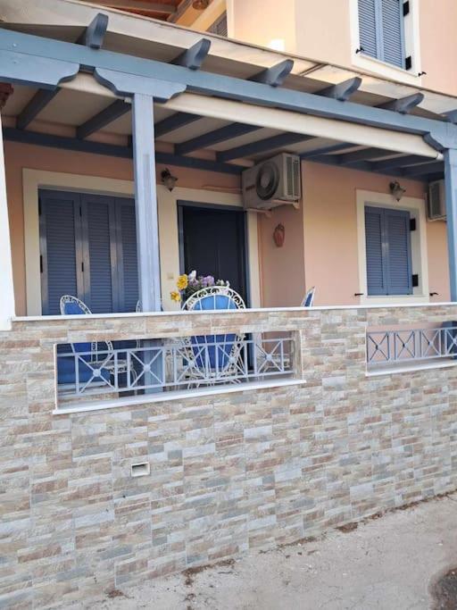a balcony with a table and chairs on a brick wall at Dimitris Guesthouse in Kapótidhes