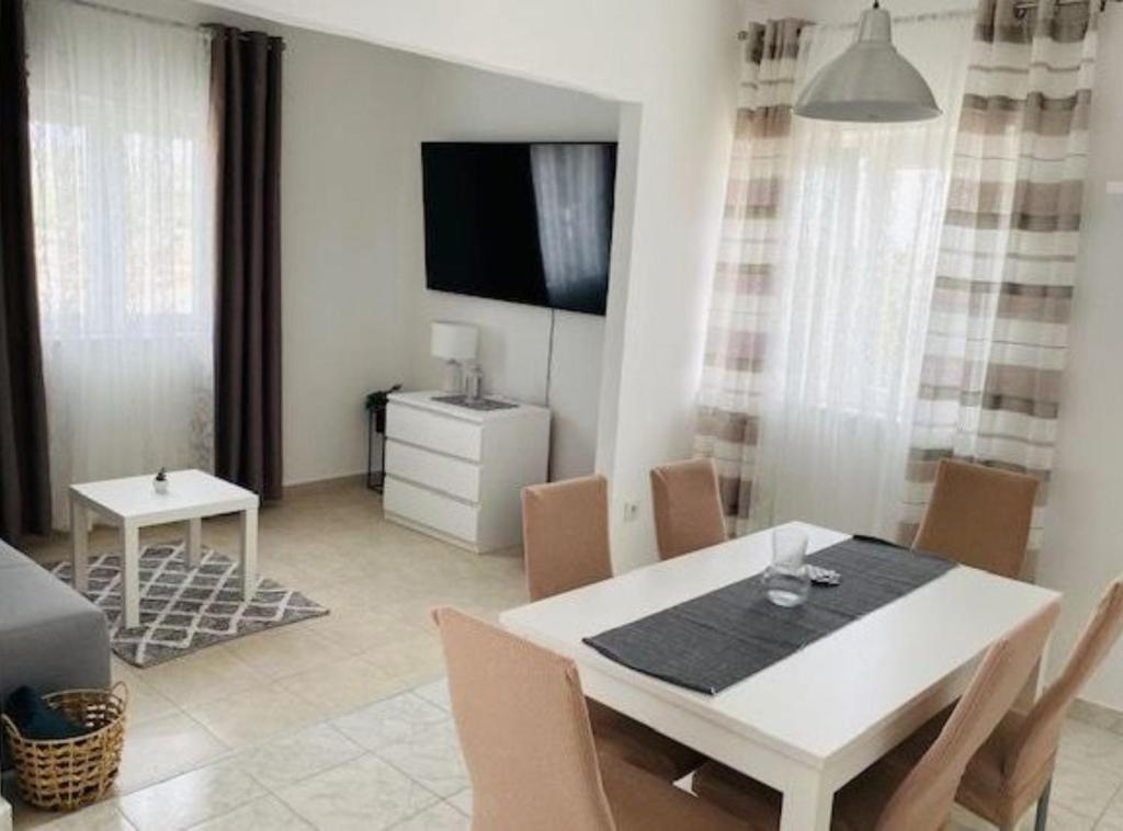 Un comedor con una mesa y sillas blancas. en Villa Brazza, en Milna