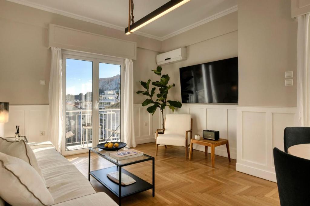 a living room with a white couch and a large window at Meliti Apartment in Plaka in Athens