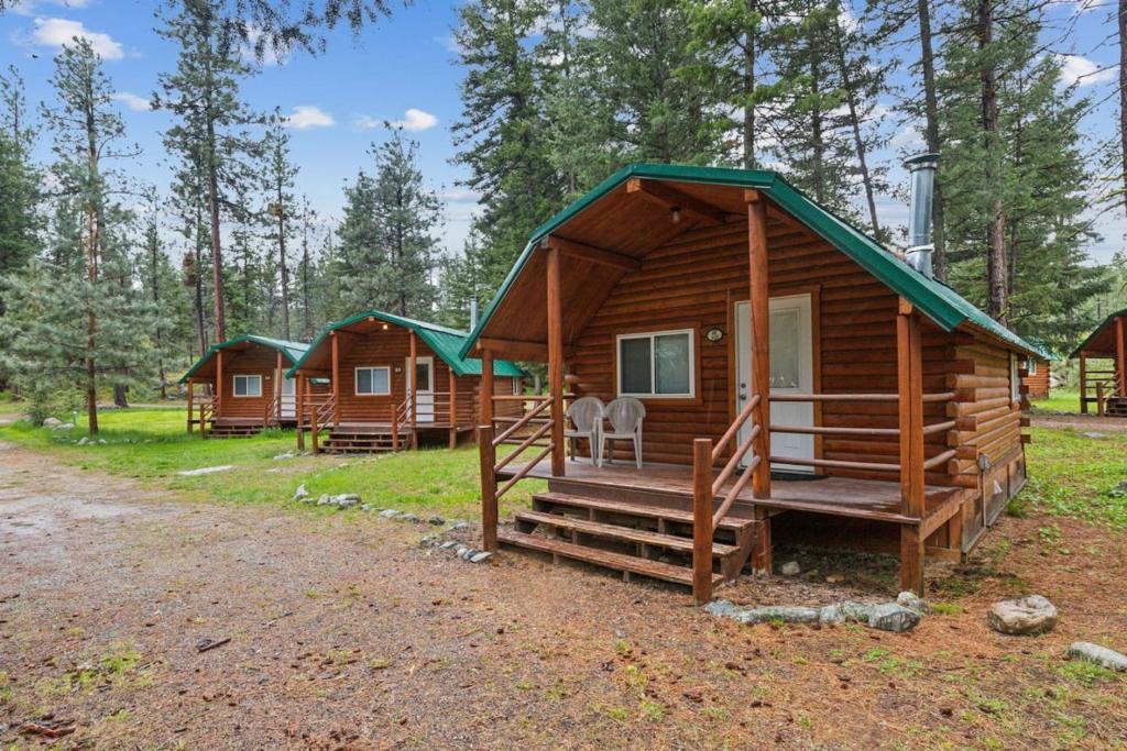 a log cabin in the woods with a porch and a porch at Lost Horse Lodge Double Queen Cabin 15 in Darby