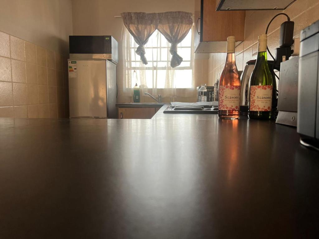 a kitchen with two bottles of wine on a counter at Nicole Guest Apartments in Germiston