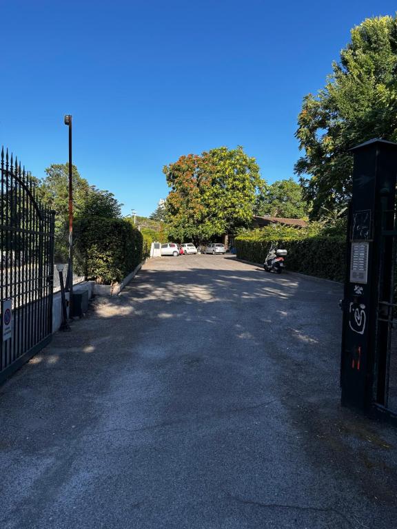 an empty parking lot with a fence and trees at Casa di Nia Pietralata in Rome