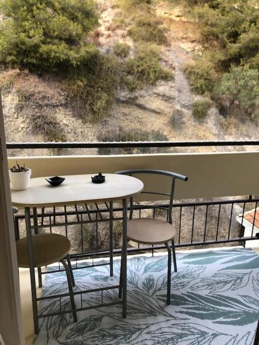 une table et deux chaises sur un balcon avec vue dans l'établissement Le Rabelais, Studio terrasse, à Nice