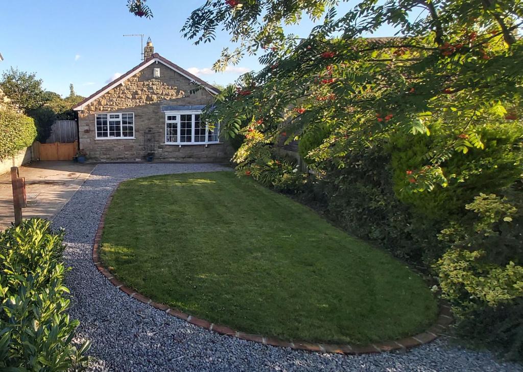 a house with a yard with a grassy lawn at Willow Cottage 4 bed, cosy stopover, dogs welcome in Thornton-le-Beans