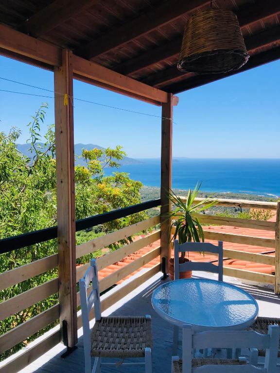 a table and chairs on a porch with a view of the ocean at Apartment in Marathokampos Samos in Samos