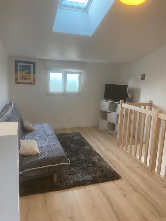 un salon avec un canapé et une télévision dans l'établissement Maison avec jardin Proche La Rochelle, à Périgny