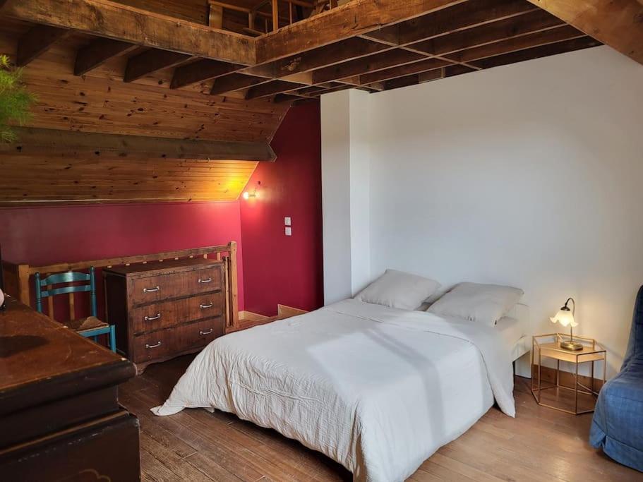 une chambre avec un lit blanc et un mur rouge dans l'établissement Maisonnette jardin - Fontainebleau, Disney, Paris, à Boissise-la-Bertrand