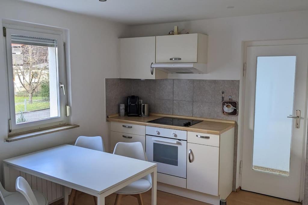 a kitchen with a white table and a table and chairs at Hiloa-Appartment in Wernau in Steinbach