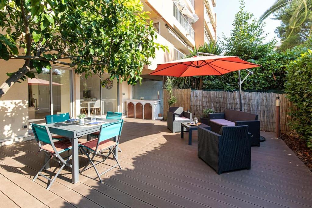 un patio avec une table, des chaises et un parasol dans l'établissement Charmant studio climatisé, à Antibes
