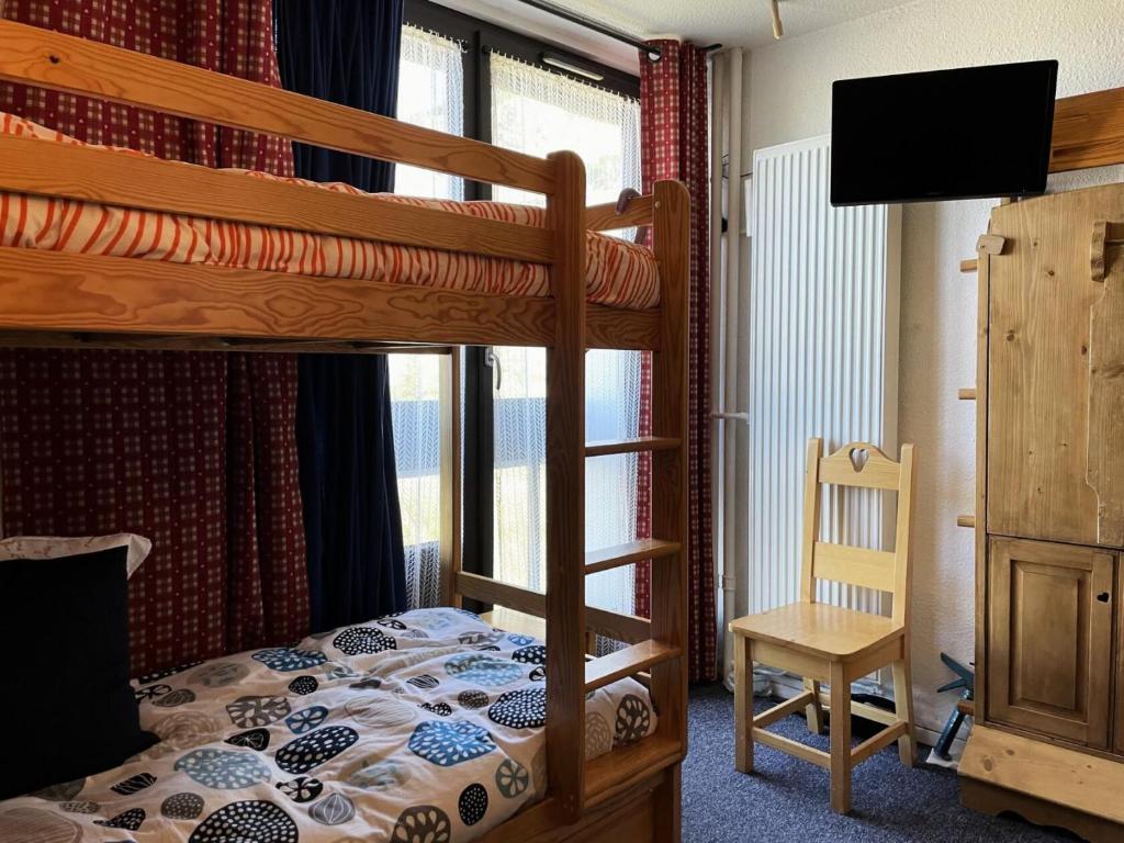 - une chambre avec 2 lits superposés et une télévision dans l'établissement Résidence Dorons - Studio pour 2 Personnes 104, aux Menuires