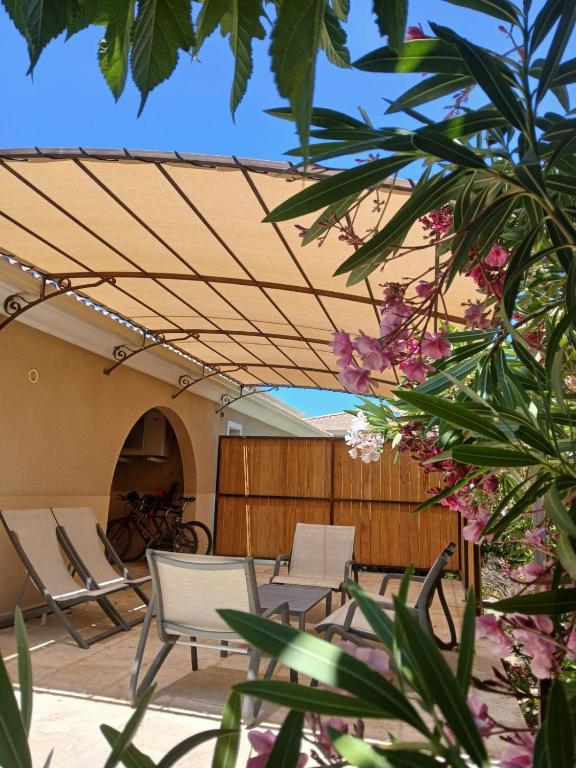 un patio avec chaises et auvent et une table dans l'établissement Les Villas Maristella, Villa Oriente, à Aregno
