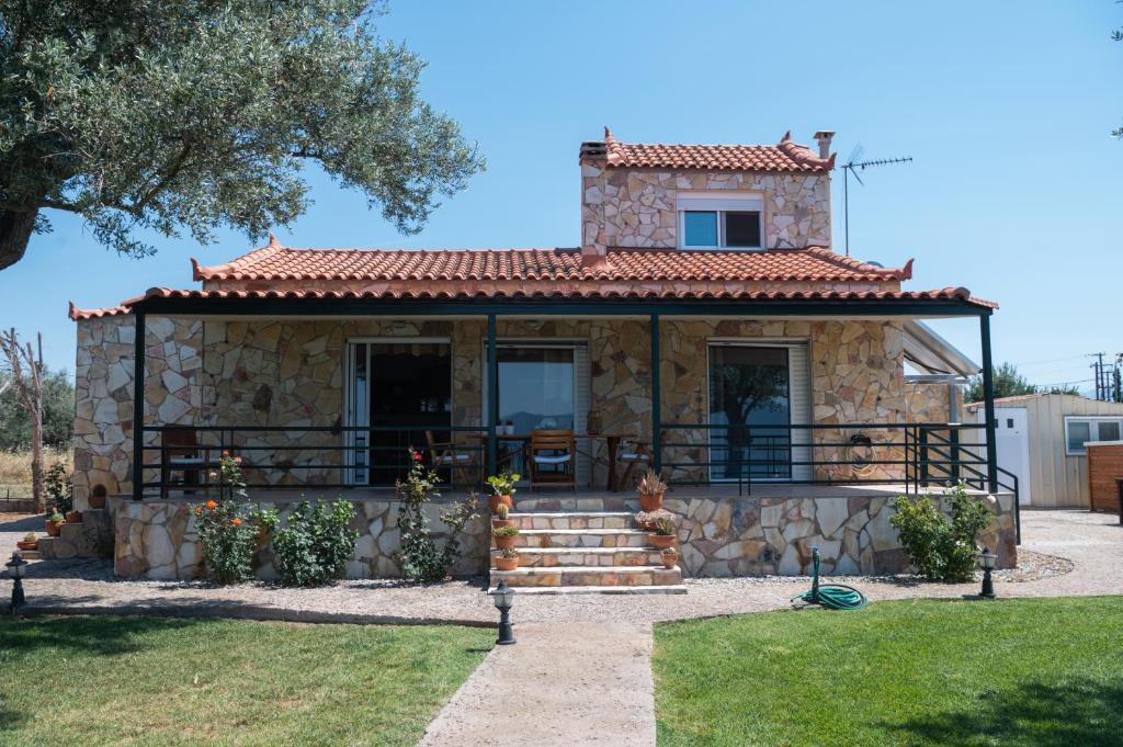 a small stone house with a porch and stairs at Luxury Beach Villa in Skála