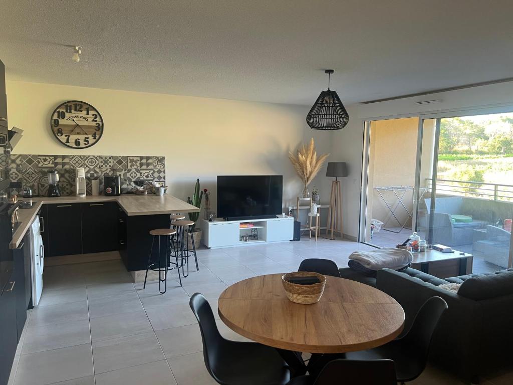 un salon avec une table et une cuisine dans l'établissement Appartement T3 avec belle vue, à Fréjus