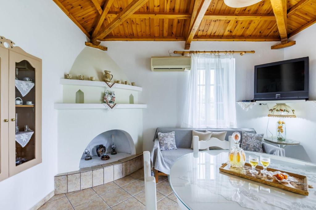 a living room with a couch and a glass table at Skopelos Sunset traditional country house in Panormos Skopelos