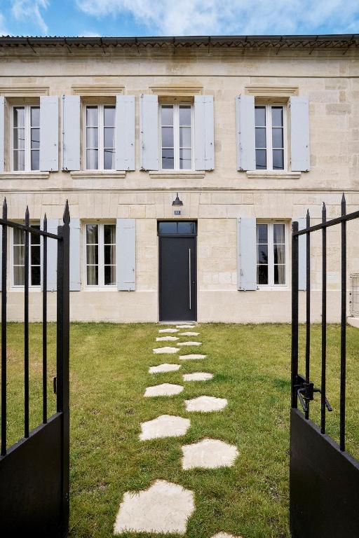 un bâtiment avec une porte noire et une cour d'herbe dans l'établissement Villa Condat, à Libourne