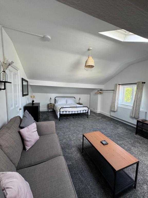 a living room with a couch and a bed at The Eaves - Victorian second floor, open plan apartment in Southport