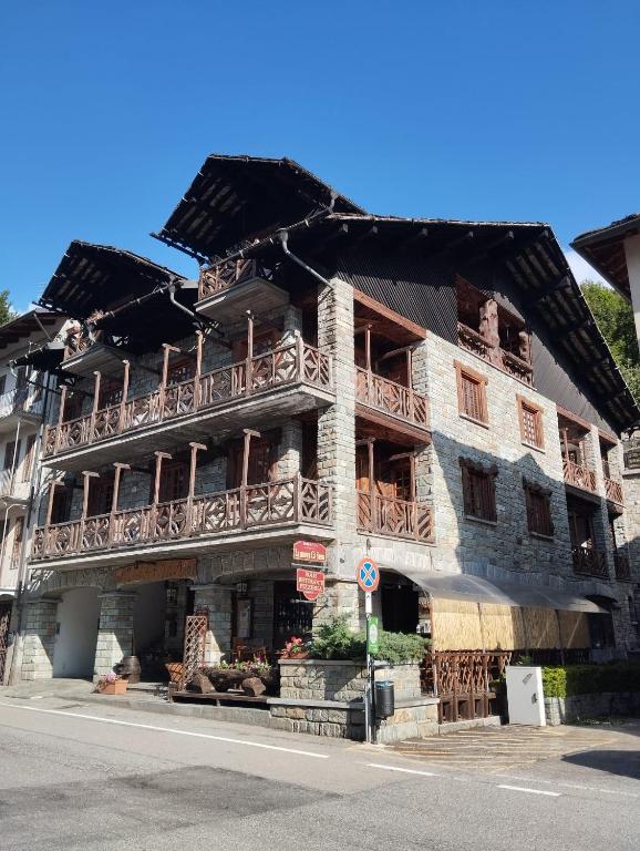 a building with wooden balconies on the side of a street at Stone House Viù - Location Blue in Viù