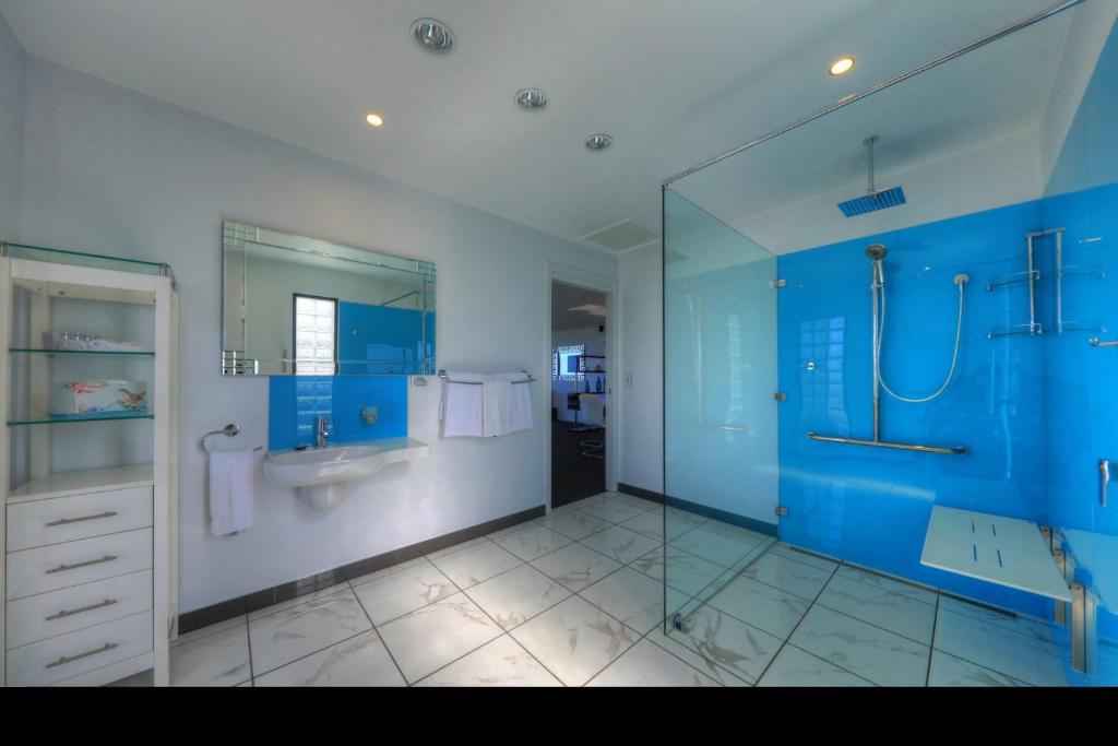 a blue bathroom with a sink and a shower at Horizon Deluxe Apartments in Stanley