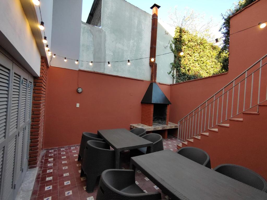 eine Terrasse mit Tischen und Stühlen und einem Kamin in der Unterkunft CASA CENTRICA EN LA CIUDAD DEL BUEN VlNO - HASTA 8 PERSONAS in Mendoza