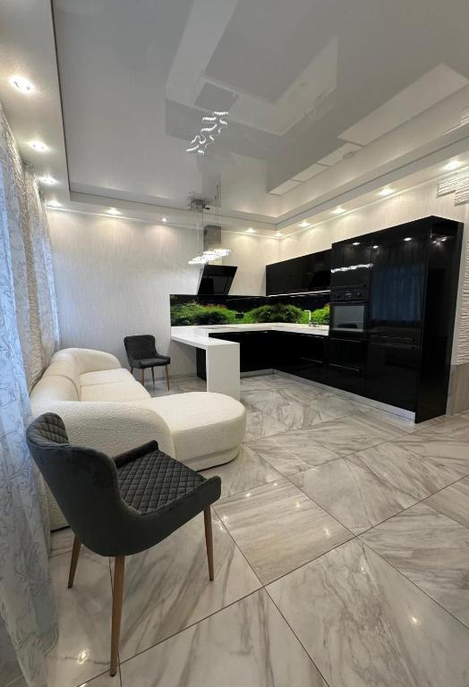 a living room with a white couch and a chair at Kairos apartment in Ventspils