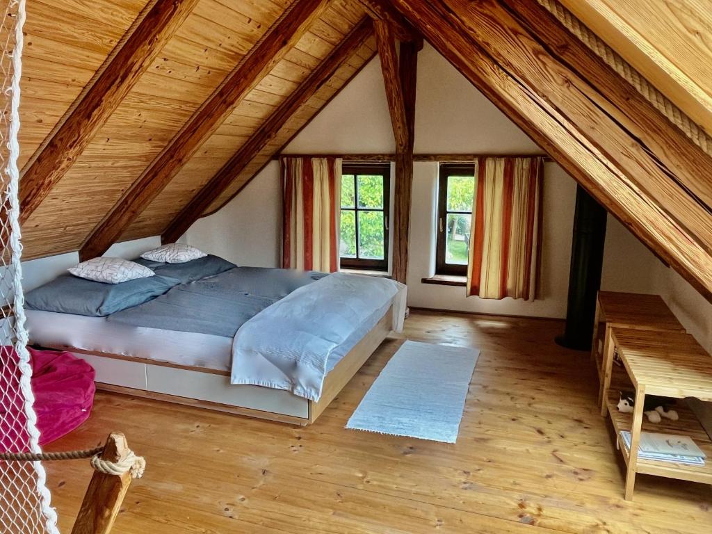 sypialnia z dużym łóżkiem na poddaszu w obiekcie Apartmány pod Kozákem w mieście Velké Popovice