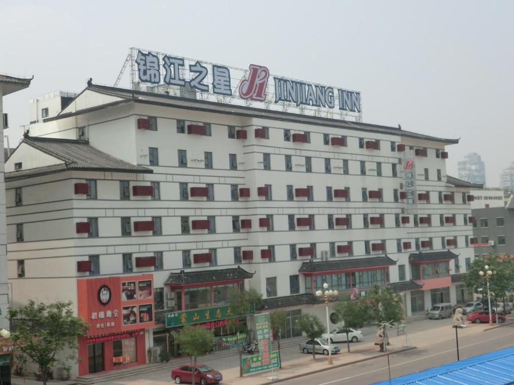 un gran edificio blanco con un cartel encima en Jinjiang Inn Linyi South Suhe Road, en Linyi
