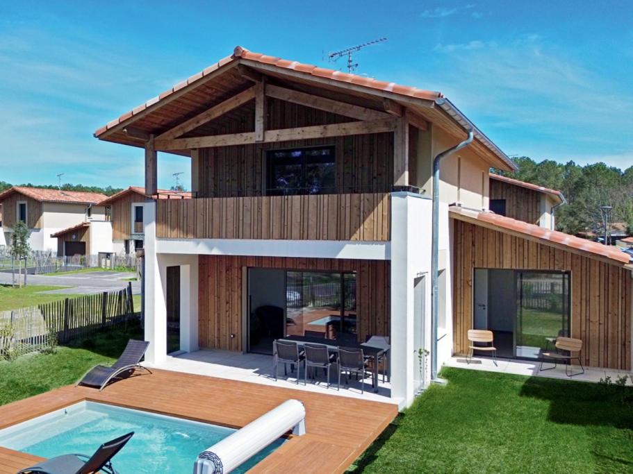 une maison avec une piscine dans l'arrière-cour dans l'établissement Le Cottage Des Glycines - Piscine chauffée, à Moliets-et-Maa