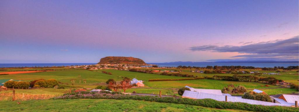 a view of a farm with a mountain in the background at Horizon Deluxe Apartments in Stanley
