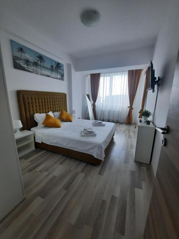 a bedroom with a bed and a large window at Apartament COSTA in Mamaia