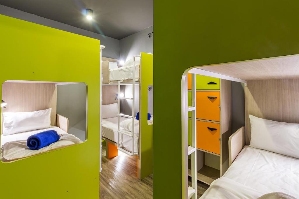 two bunk beds in a room with green walls at iSanook Hostel in Bangkok