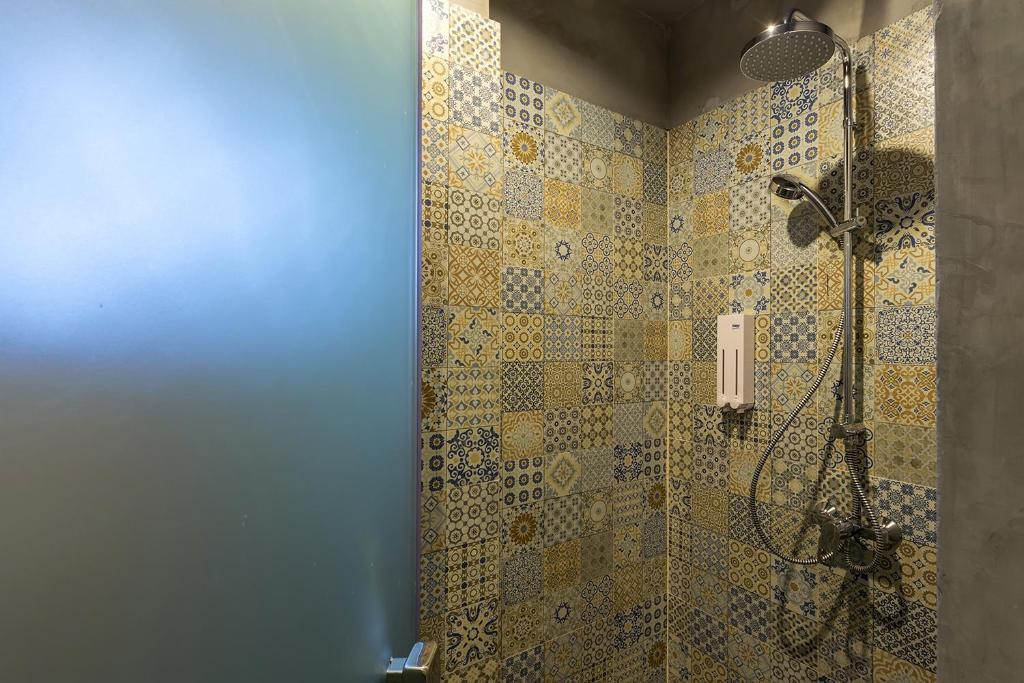 a bathroom with a shower with mosaic tiles at iSanook Hostel in Bangkok