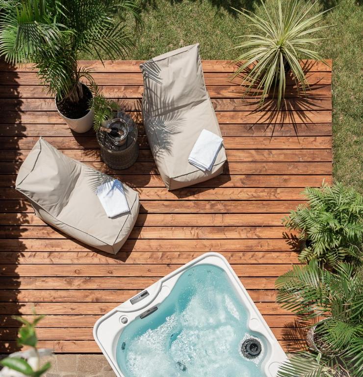a bath tub sitting on a wooden deck with two pillows at Bardolino Suite in Bardolino
