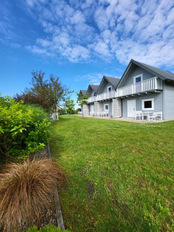 a large house with a lawn in front of it at Domki Letniskowe Gris in Grzybowo