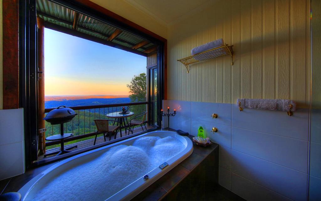 un ampio bagno con vasca e ampia finestra di At Remingtons Private Cottages Montville a Montville