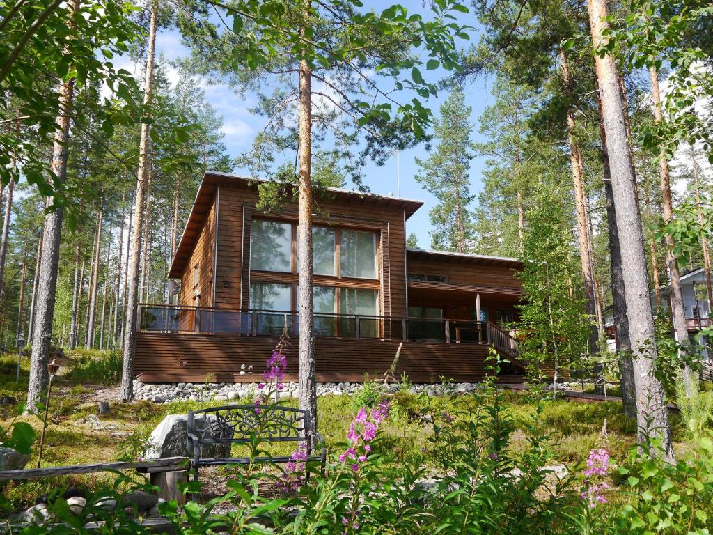 una cabaña de madera en el bosque con árboles en PielisLinna en Kolinkylä