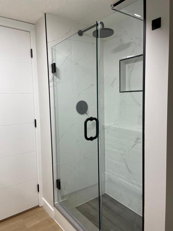 a shower with a glass door in a bathroom at Flora's House in Calgary