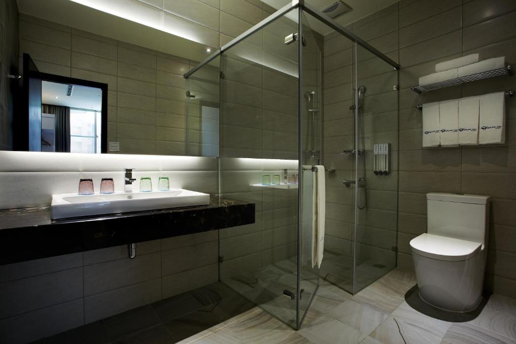 a bathroom with a shower and a toilet and a sink at Airline Inn Green Park Way in Taichung