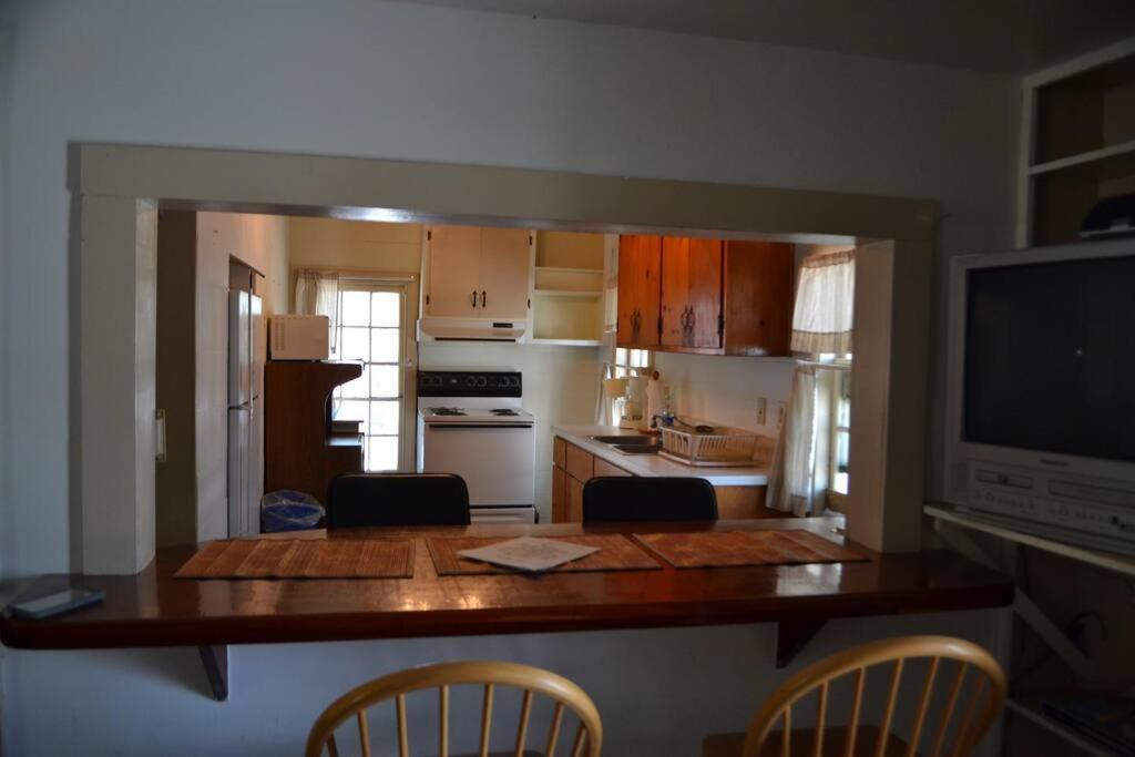 a kitchen with a table and chairs and a kitchen with a television at Beaufort Harbour Suites West Lodge in Beaufort