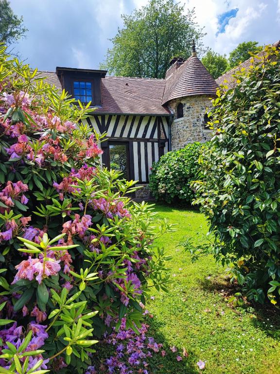 クウェットヴィルにあるLa longère dans la prairieの前に花が飾られた古い家