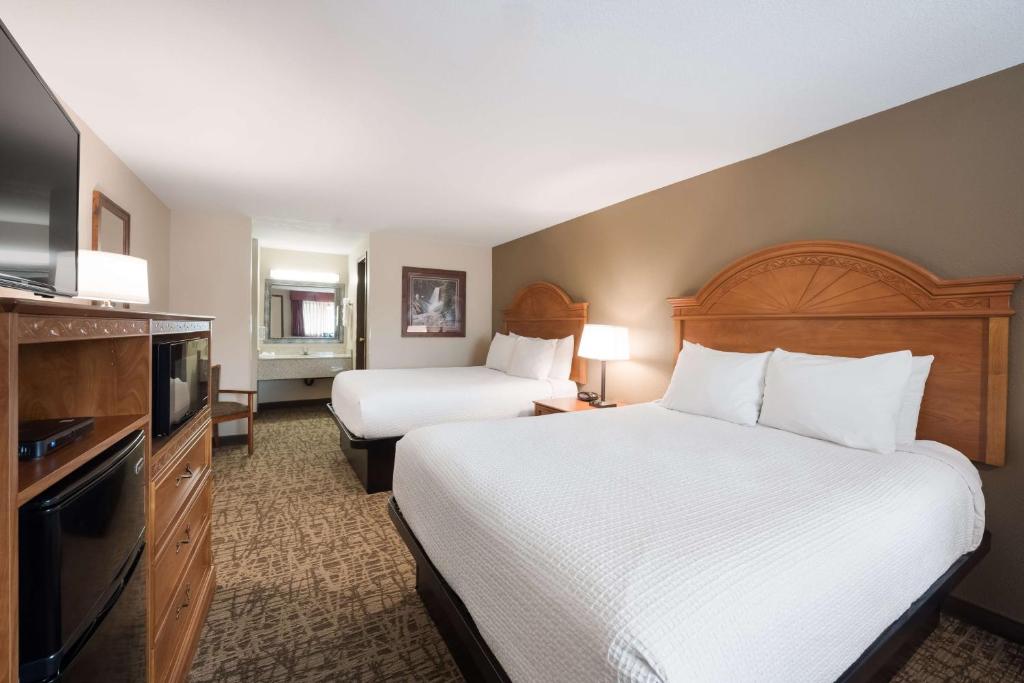 a hotel room with two beds and a flat screen tv at Best Western Bidarka Inn in Homer