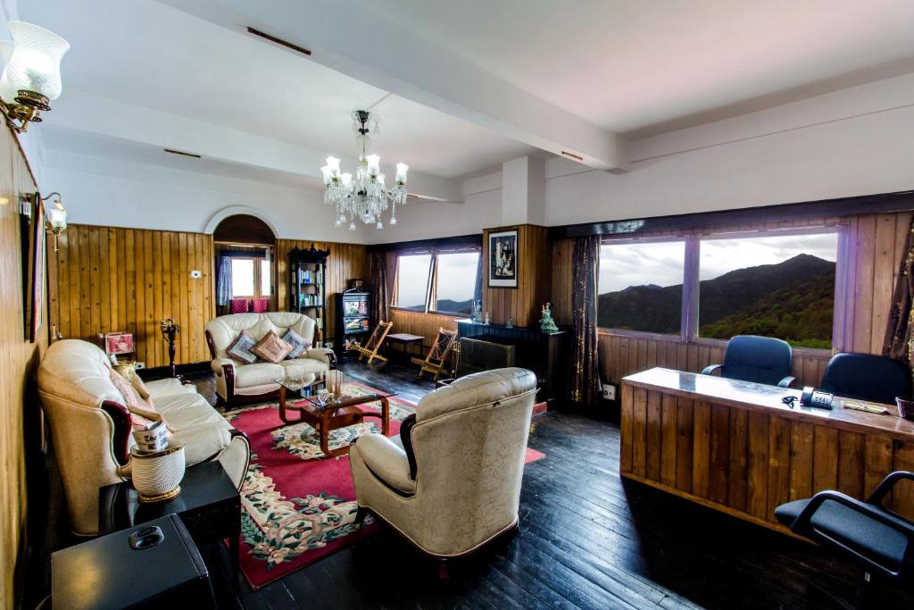 a living room filled with furniture and a large window at Central Gleneagles Heritage Resort Former Bungalow of Ex-TATA Chairman Russi Mody The Mall Road Darjeeling in Darjeeling