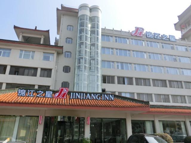 a large building with a sign in front of it at Jinjiang Inn Xiangyang Nanshan Tanxi Road in Xiangyang