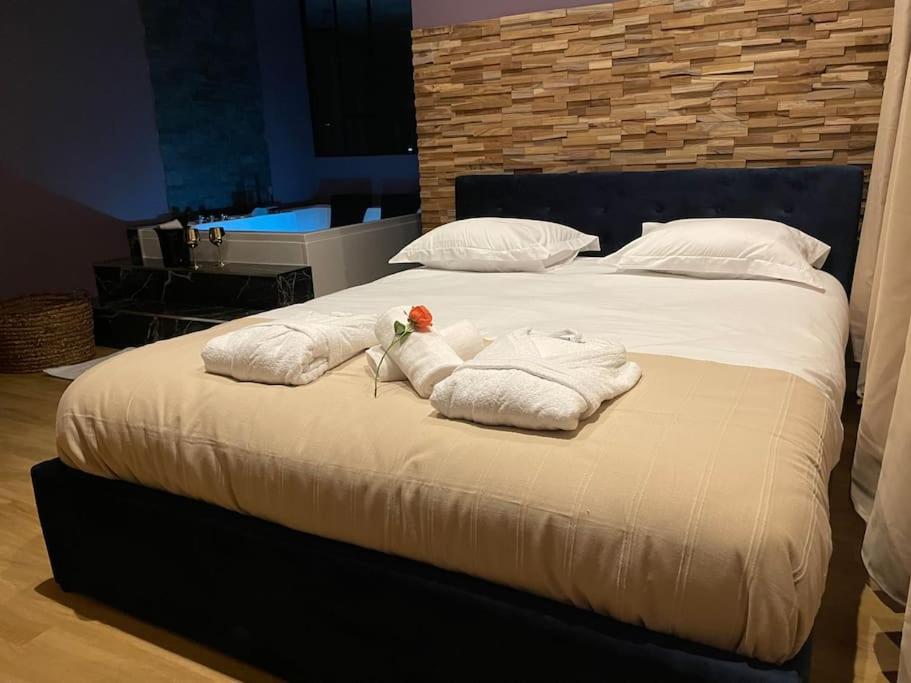a bedroom with a bed with towels on it at Le Cocon des Granges - Suite Sauna Jaccuzi SPA in Bonnières-sur-Seine