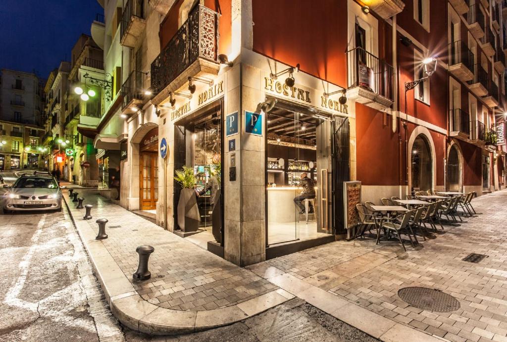 una calle de la ciudad por la noche con un restaurante en Hostal Noria, en Tarragona