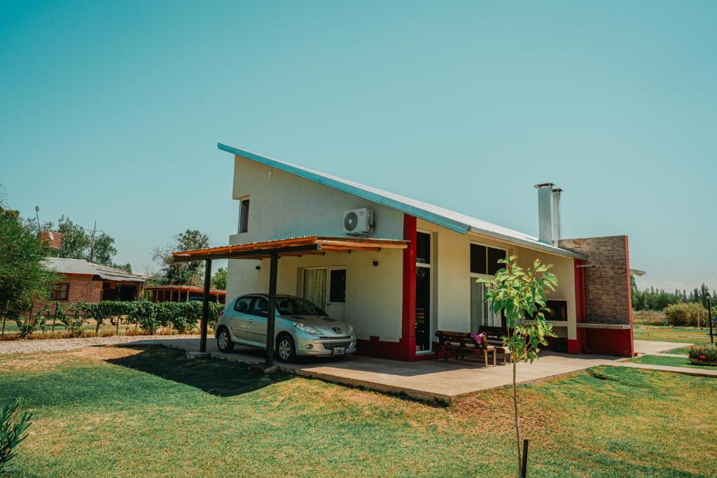 une petite maison avec une voiture garée devant dans l'établissement Cabañas Alma de Diamante, à San Rafael