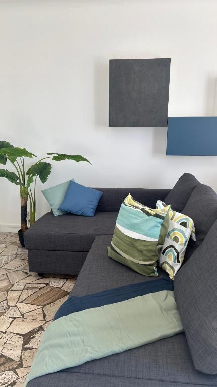 un canapé avec des coussins dessus dans un salon dans l'établissement Appart Proche Orly, à Viry-Châtillon