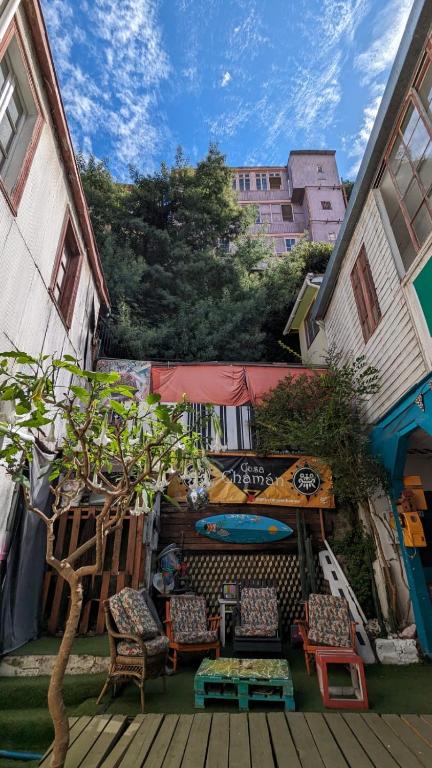 um pátio com cadeiras, uma mesa e uma árvore em Art Hostel Casa Chaman em Valparaíso