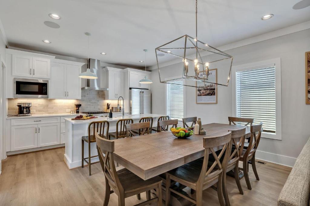 Una cocina y un comedor con mesa y sillas de madera. en Soprano - Private Rooftop - 8 mins to Broadway, en Nashville