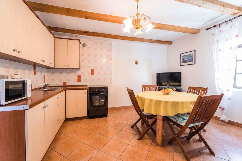 a kitchen with a table with a yellow table cloth at Apartment in Bribir 41909 in Bribir